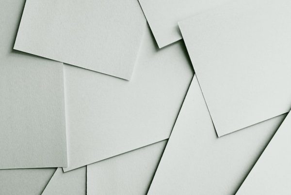 Scattered sheets of white paper covering the entire frame